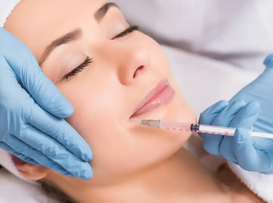 A client receiving a professional dermal fillers injection for lip plumping at Xthetics Med Spa.